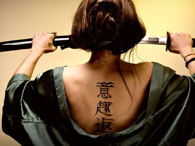 Kanji tatuado nas costas de uma mulher